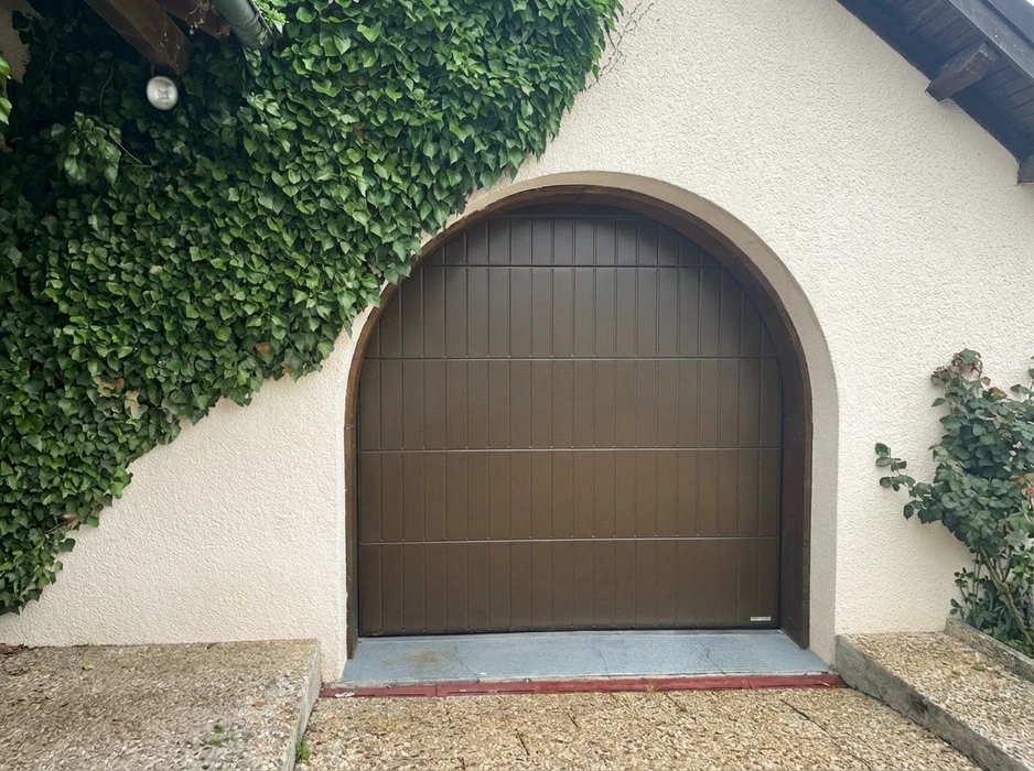 Façade d'une maison individuelle bleue avec clôture en aluminium anthracite à barreaudage horizontal, piliers béton