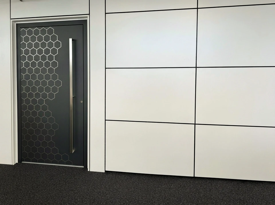 Entrée moderne d'une maison contemporaine avec porte d'entrée grise et panneau latéral vitré