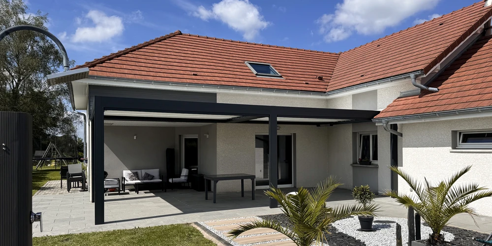 Façade d'une maison individuelle bleue avec clôture en aluminium anthracite à barreaudage horizontal, piliers béton
