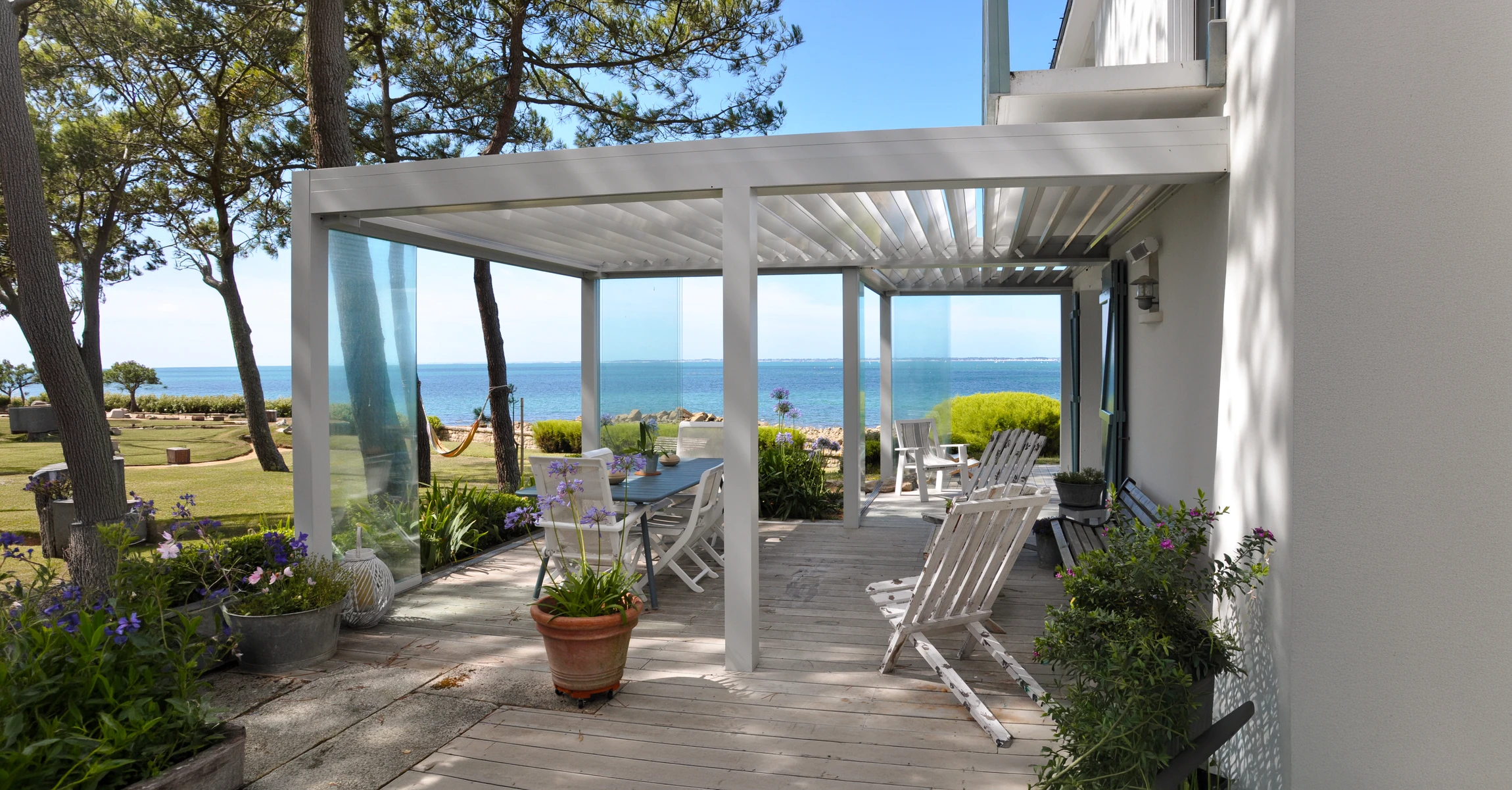 Terrasse moderne avec pergola bioclimatique à lames orientables, mobilier contemporain et piscine
