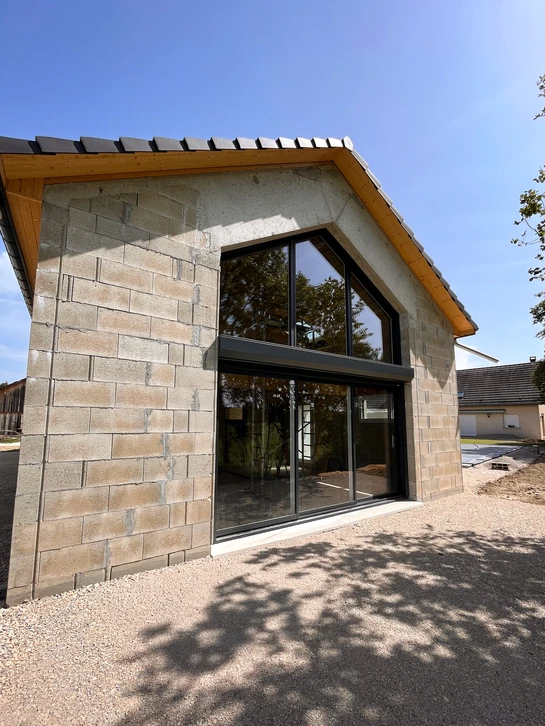 Intérieur résidentiel avec fenêtres en bois aux vitres reflétant l'obscurité extérieure